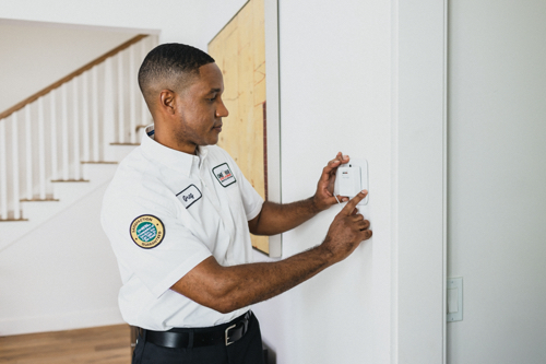 One Hour tech installing a thermostat for a Birmingham, AL homeowner