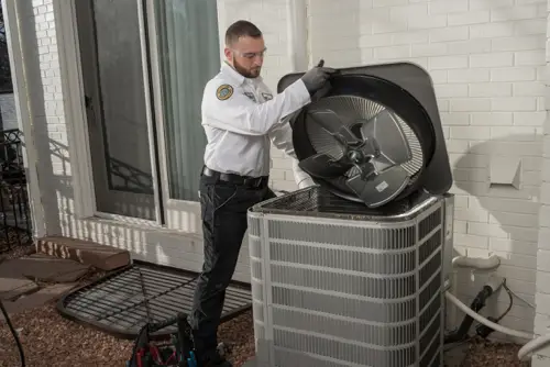 One Hour Air Conditioning & Heating technician performing AC unit maintenance outside a home in Birmingham, AL, ensuring optimal cooling system performance.