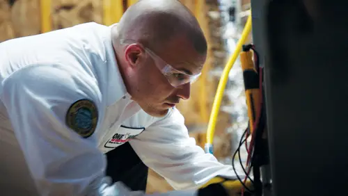 One Hour Air Conditioning & Heating technician performing HVAC repair in an attic space in Birmingham, AL, ensuring optimal heating and cooling system efficiency.