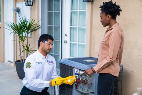 One Hour Air Conditioning & Heating technician diagnosing an outdoor AC unit for a homeowner in Birmingham, AL, ensuring reliable cooling system performance.